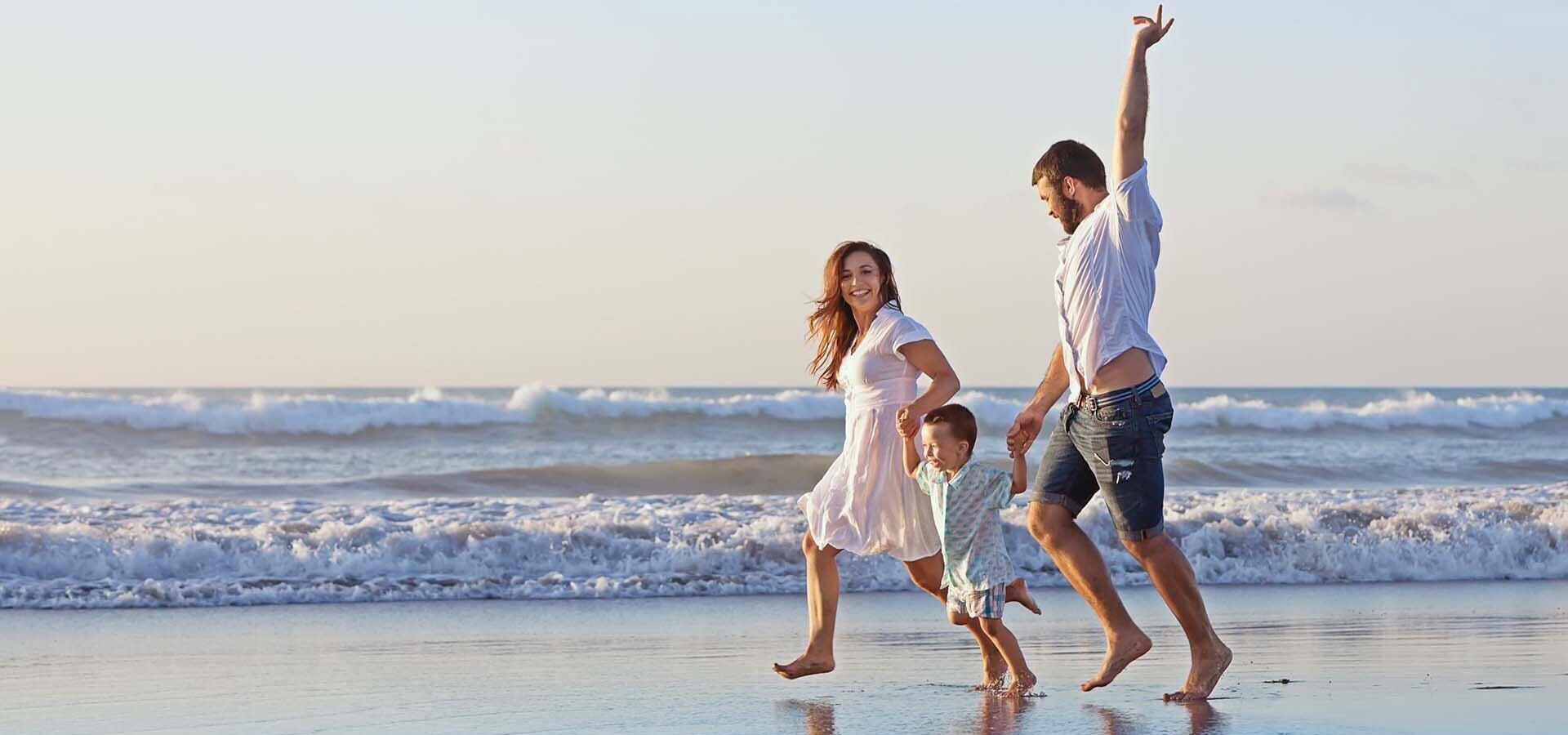 family running on a beach