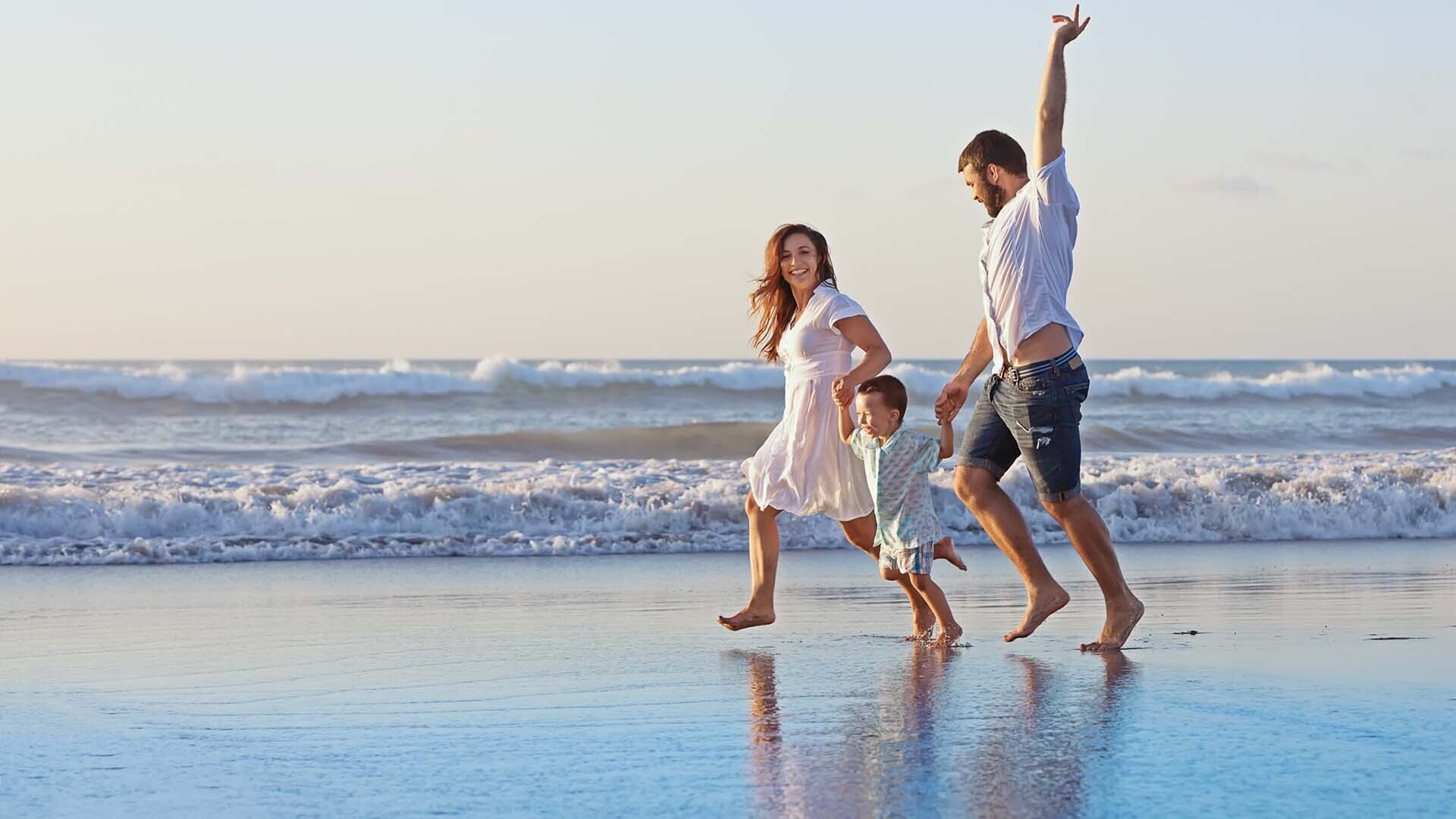 family running on a beach